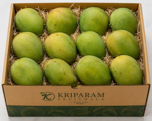 A cardboard box of 12 langada mangoes from banaras nestled in shredded paper, with the brand name 'Kriparam Fruitwala' printed on the front.